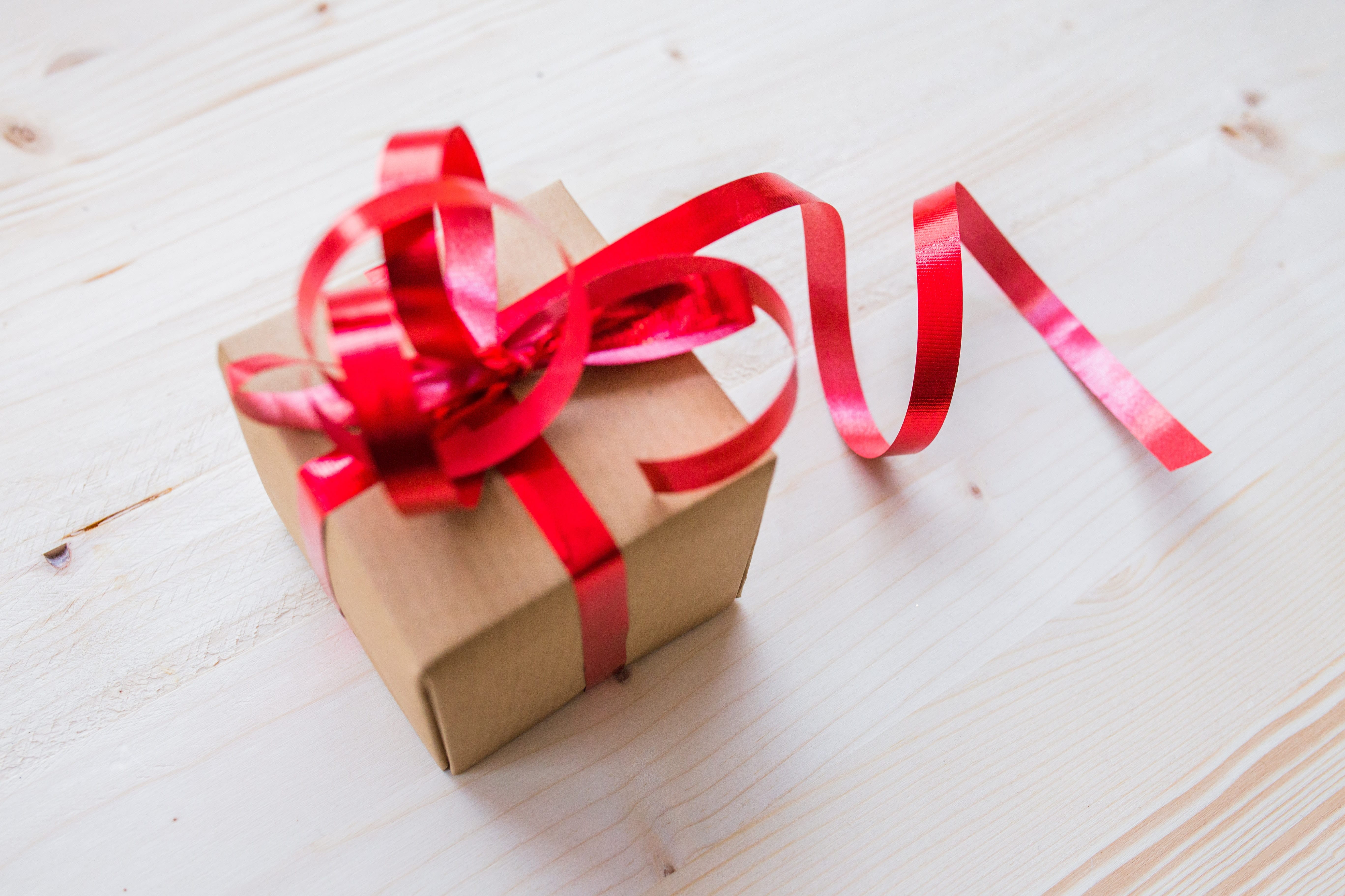 Small Gift with a red bow on a wooden table