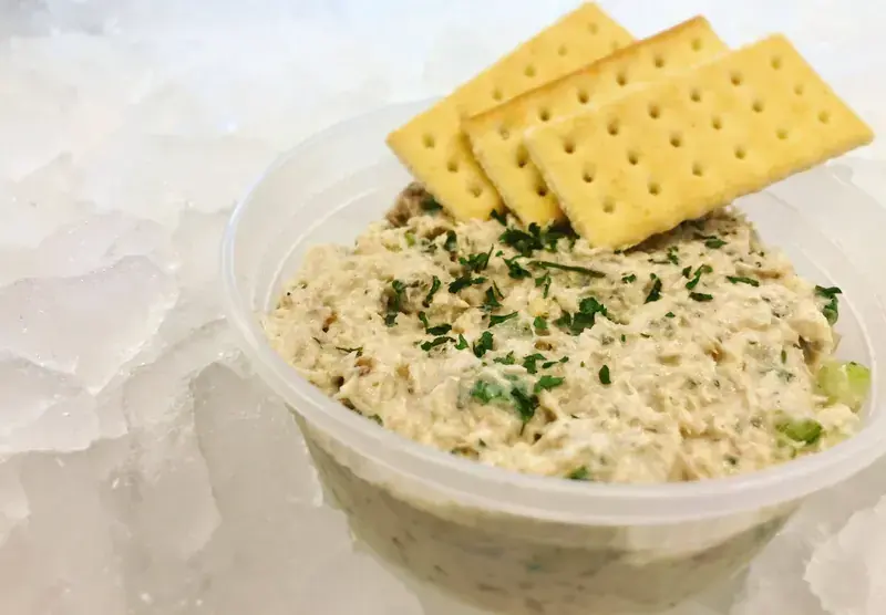 A tub of homemade smoked fish dip topped with crackers